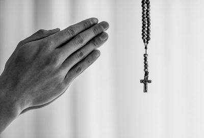 praying hands and cross