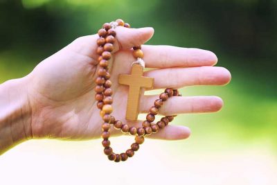 woman hand with wooden rosary